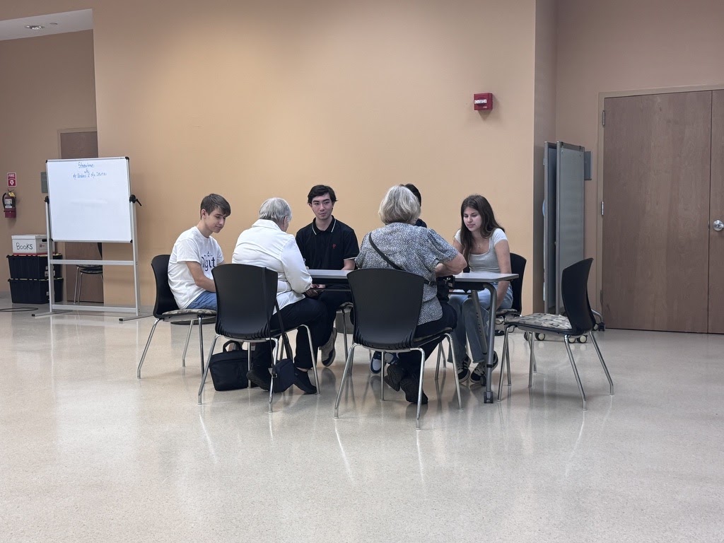 Participants gathered around a table for digital literacy instruction