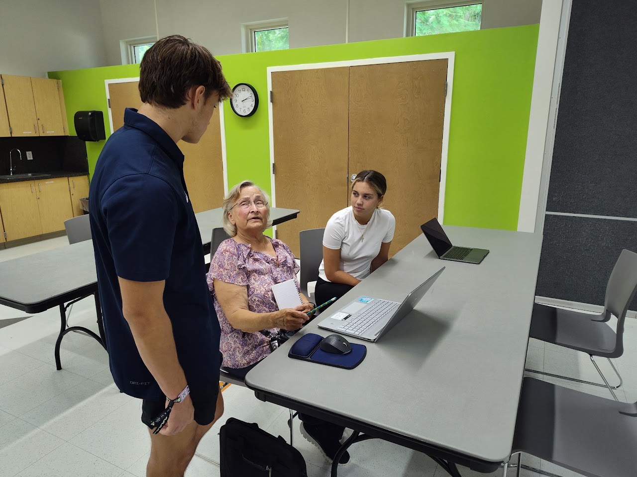 An instructor helping older adults use a computer