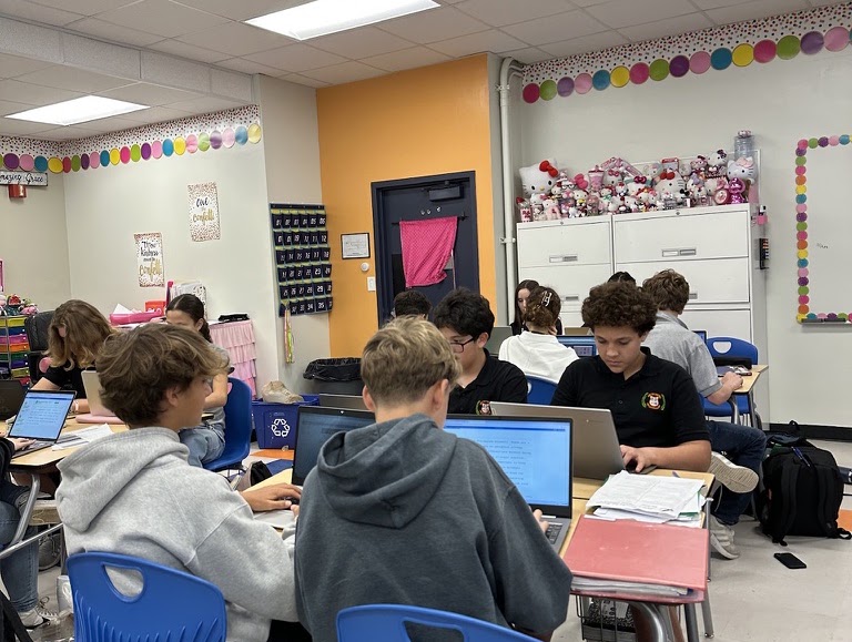 Students collaborating on laptops during a classroom workshop