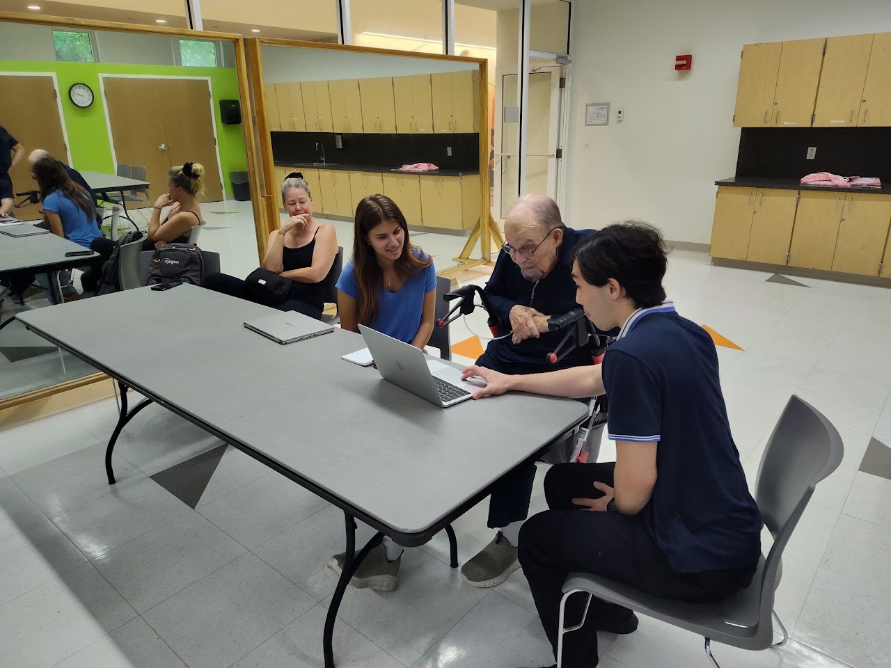 MDLP instructors working with adults around a laptop